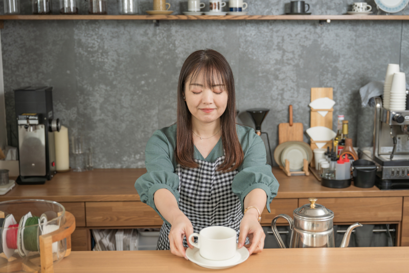 シドニーのカフェでエプロンをつけたスタッフが接客している写真