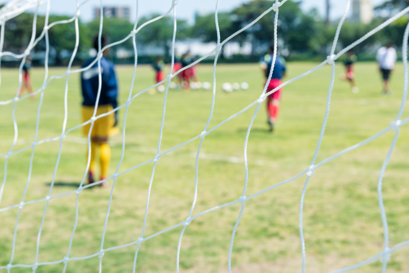 試合終盤にピッチで戦う選手たちの写真
