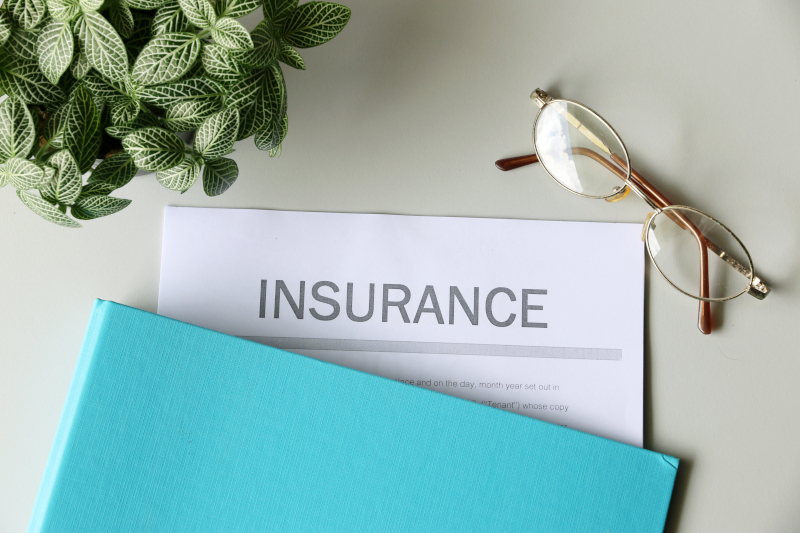 「INSURANCE」と書かれた保険証書がデスクに置かれている様子