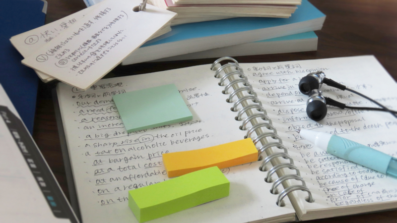 ノートに英語のフレーズや発音メモを書き留めている様子