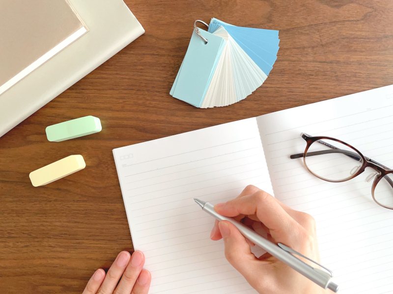 ノートに手書きで英語のフレーズをまとめて勉強する様子