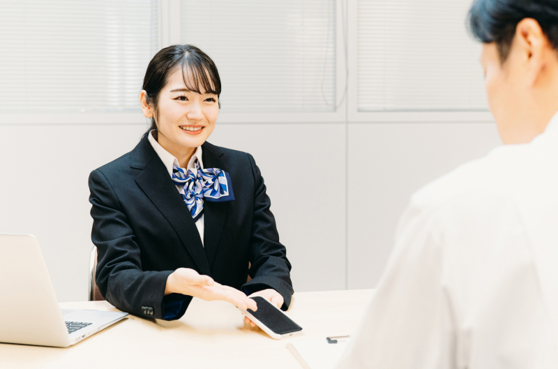 携帯電話キャリアショップの店頭で説明を受ける様子