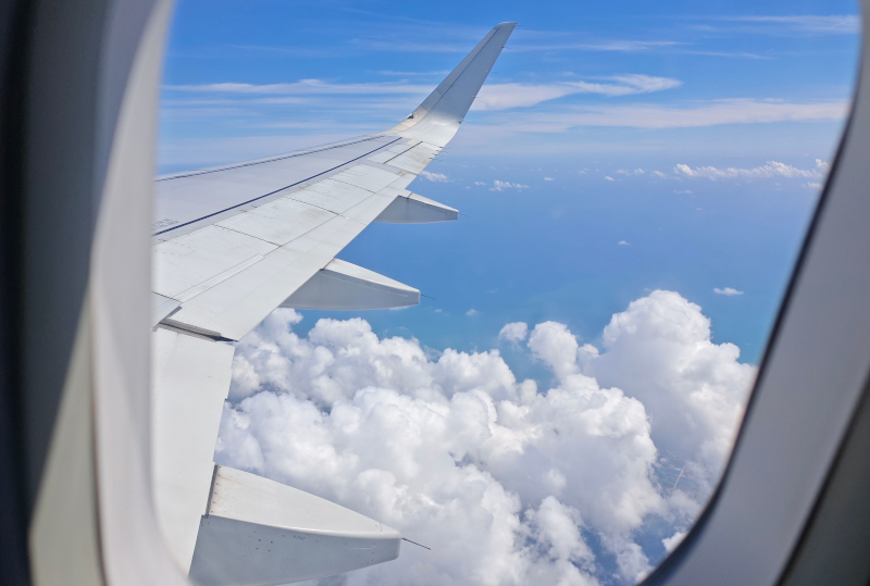 飛行機の窓から見える雲と翼